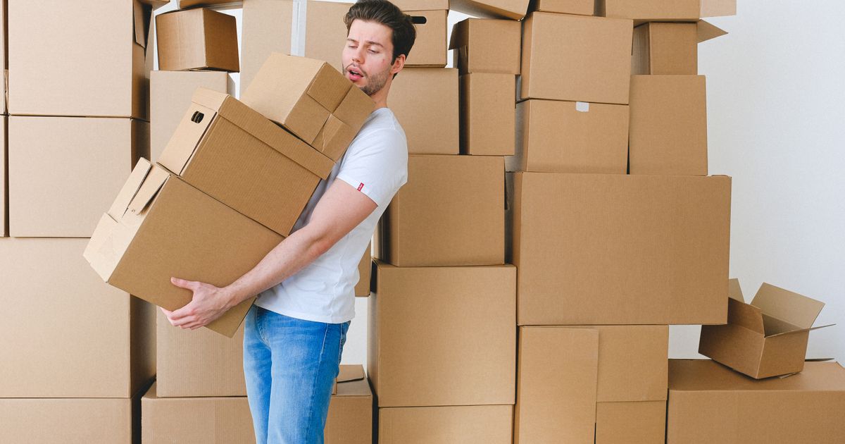Operario cargando cajas de cartón durante una mudanza a un departamento