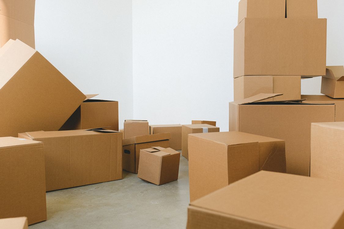 Cajas de cartón apiladas en el piso de una oficina vacía durante un proceso de mudanza